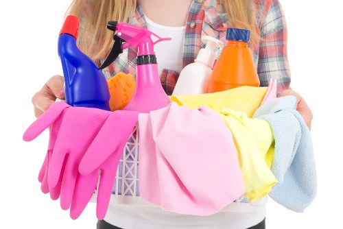 Room-by-room house cleaning checklist beside cleaning tools
